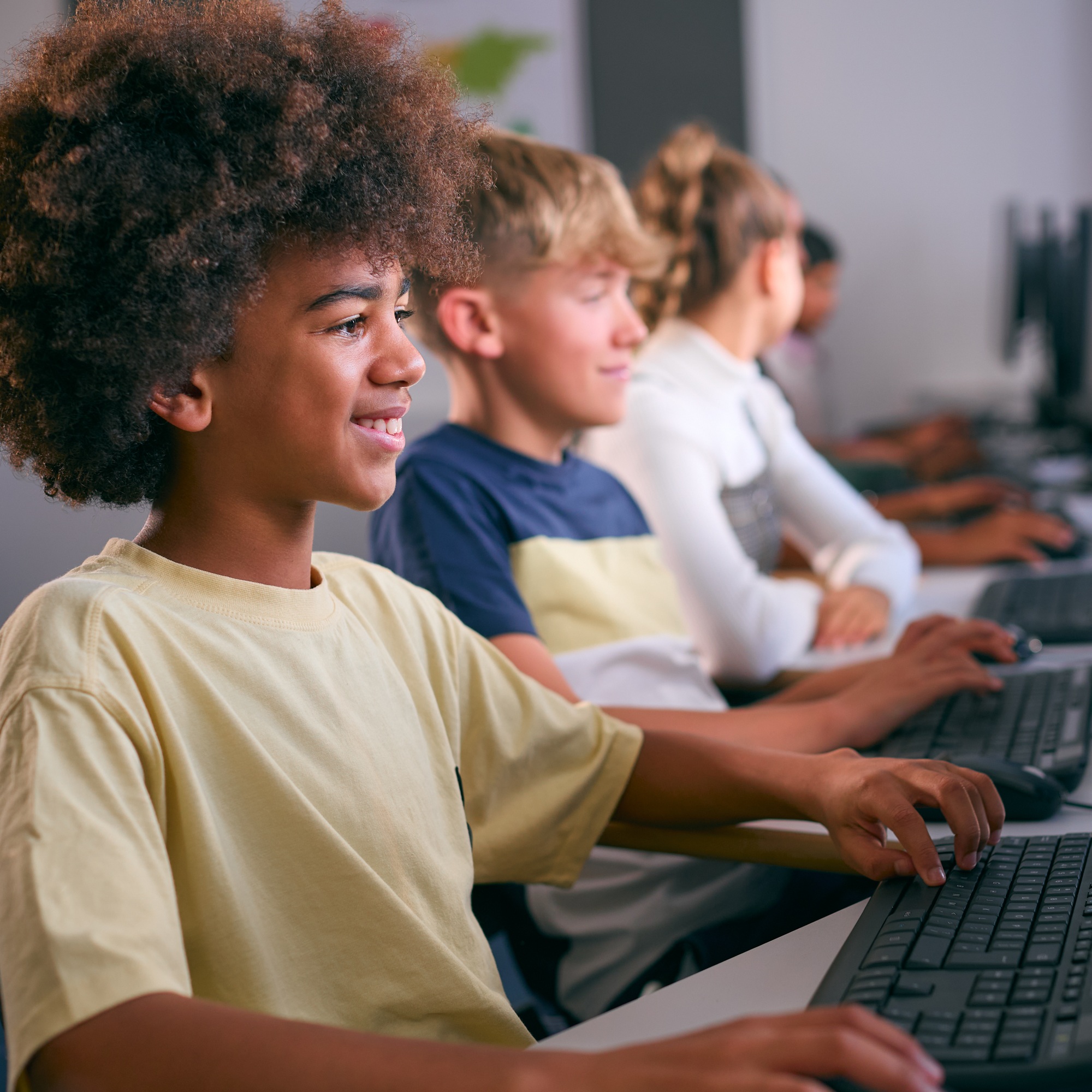 Multi-Cultural Group Of Secondary Or High School Students At Computers In IT Class